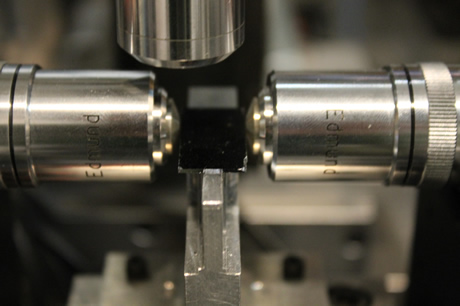 Muestra en chip de silicio con guías de onda excitadas con objetivos de microscopio.