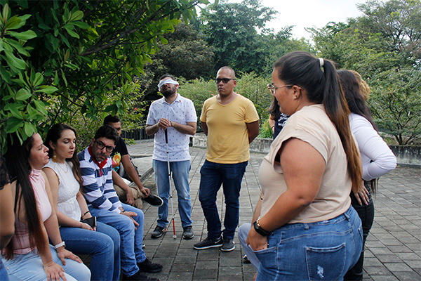 El estudiante Daniel Buriticá se quedó con los ojos vendados durante la conversación como ejercicio personal de reconocimiento de voces. Foto: Unimedios.
